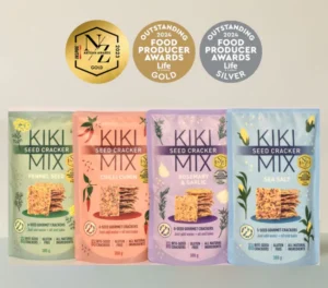 Lineup of Kiki Seed Cracker Mixes in four flavours: Fennel Seed, Chilli Cumin, Rosemary & Garlic, and Sea Salt. Gluten-free, plant-based, 5-seed gourmet crackers made with all-natural ingredients, perfect for snacking, dips, and cheese platters. Awards for quality displayed above the packages.